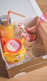Onze-kinderbox-is-steeds-gevuld-voor-1-kindje-herbruikbaar-bekertje-gevuld-met-vanille-aardbei-potje-discobolletjes-flesje-fruitsap-potje-snoepjes